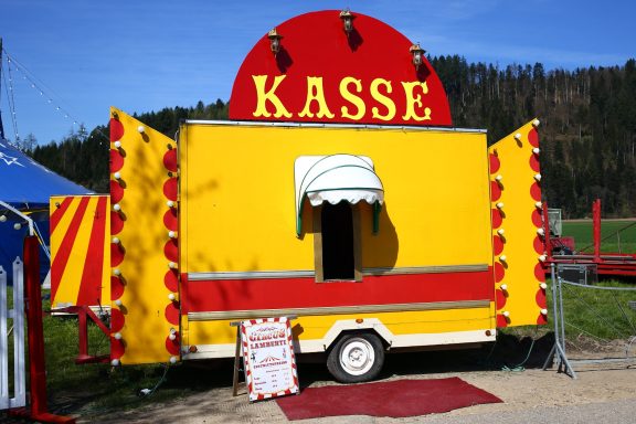 Bunter Kassenstand mit rotem und gelbem Design auf einem Außenbereich.