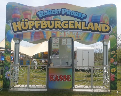 Bunter Eingang zu einem Hüpfburgen-Festival mit Kasse.